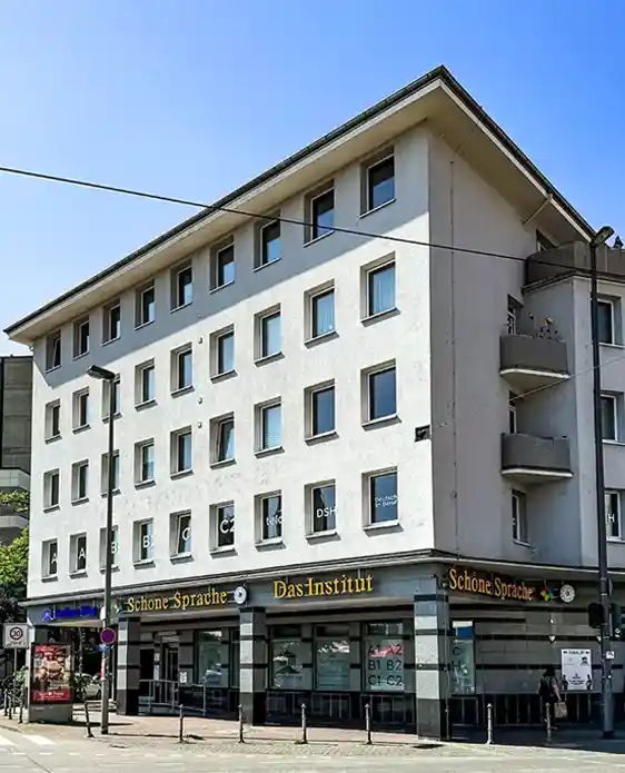 Eckgebäude des Instituts Schöne Sprache mit sichtbaren Fensterbeschriftungen für Sprachniveaus (A1-C2) und Prüfungen – das offizielle telc Prüfungszentrum in Frankfurt.